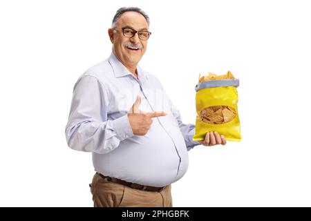 Cheerful mature man holding a bag of tortilla crisps and pointing isolated on white background Stock Photo