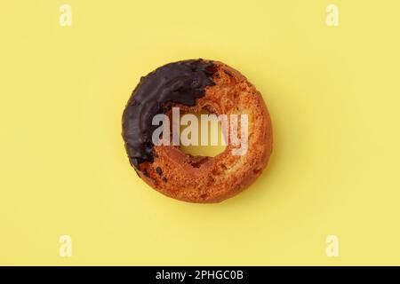 old fashioned doughnut chocolate on plate isolated on yellow background Stock Photo