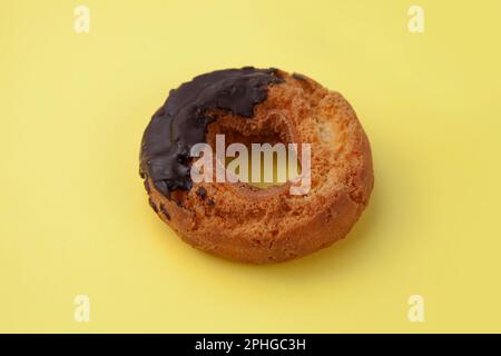 old fashioned doughnut chocolate on plate isolated on yellow background Stock Photo