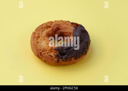 old fashioned doughnut chocolate on plate isolated on yellow background Stock Photo