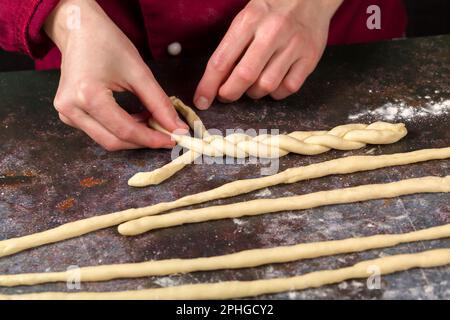 The confectioner prepares the decor for Easter cakes in the form of pigtails from the dough Stock Photo