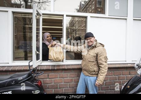 AMSTERDAM - Volunteers hand out healthy packages for the iftar in a nursing home. During the fasting month of Ramadan, Muslims eat this meal after sunset. ANP DINGENA MOL netherlands out - belgium out Stock Photo