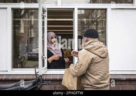 AMSTERDAM - Volunteers hand out healthy packages for the iftar in a nursing home. During the fasting month of Ramadan, Muslims eat this meal after sunset. ANP DINGENA MOL netherlands out - belgium out Stock Photo