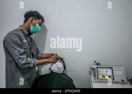 BOGOR, INDONESIA - March 27, 2023: A resident carries out an eye test using an eye test equipment at the Ainun Cahaya Medika eye clinic, Bogor Regency Stock Photo