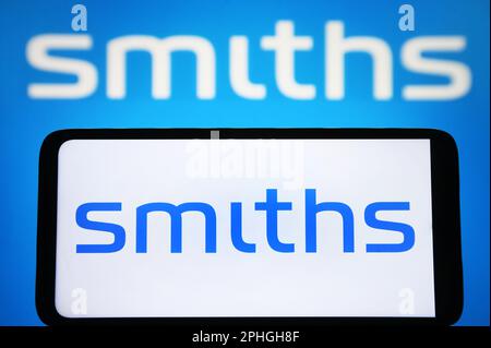 In this photo illustration, Smiths Group plc logo is seen displayed on a smartphone and on a pc screen. Stock Photo