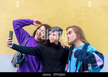 Young diverse friends taking selfies with a mobile phone outdoors. Stock Photo
