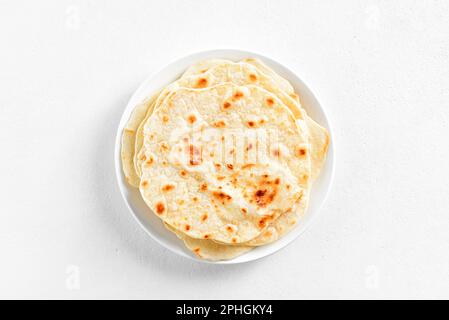 Wheat flat bread on plate over white stone background with copy space. Top view, flat lay Stock Photo