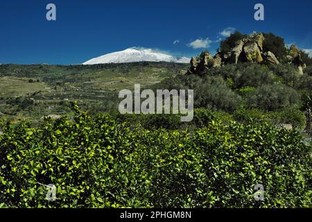 spring in Sicily landscape with Mount Etna covered in white snow against blue sky, Italy Stock Photo