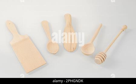 Wooden kitchen utensils.Various wooden cooking tools arranged in a semicircle on a light background. Stock Photo