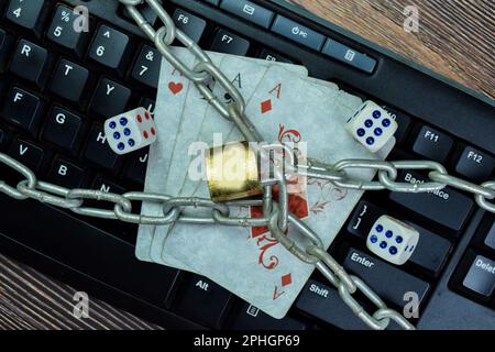 Concept of padlock and playing cards isolated on keyboard. Online gambling concept Stock Photo