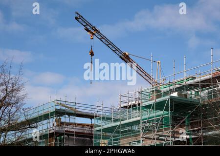 crane scaffolding and safety nets on construction site building new social housing block strandtown, east belfast, northern ireland, uk Stock Photo