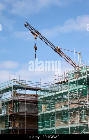crane scaffolding and safety nets on construction site building new social housing block strandtown, east belfast, northern ireland, uk Stock Photo