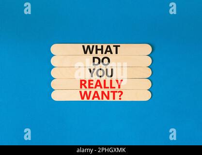 What do you really want symbol. Concept words What do you really want on wooden stick. Beautiful blue table blue background. Business and what do you Stock Photo