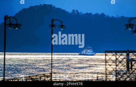 Small passenger  ship  sails  to the town  of Como   Sunset on Lake Como in early spring Stock Photo