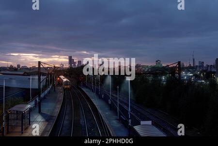 Ashburys railway station is in Manchester, the Manchester-Glossop  train line with the citys skyline of Manchester and the new towers of the city Stock Photo
