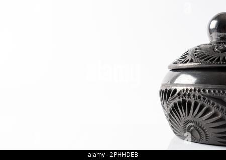 Typical Mexican handicraft. Close-up shot of a black clay pot handcrafted in Oaxaca, Mexico. White background. Copy space. Stock Photo