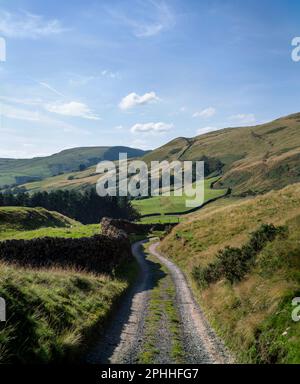 Country lane in the English Peak District on a summers day with clear skyies, dry stone walls in the Alport Valley in the Dark Peak area of Derbyshire Stock Photo