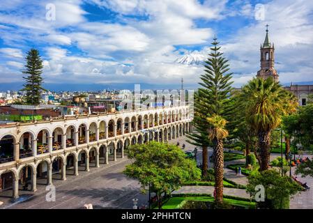 Areqiupa, Peru, view of the city's main square Plaza de Armas, the colonial buildings with archways and the snowcapped peak of the Chachani volcano in Stock Photo