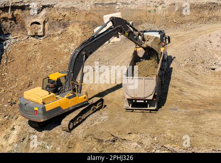 Excavator and truck working in construction, loading on truck Stock Photo