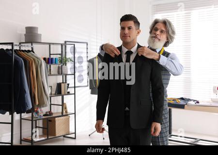 Professional tailor working with client in atelier Stock Photo