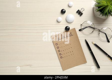 Flat lay composition with unfilled To Do list and glasses on wooden table Stock Photo