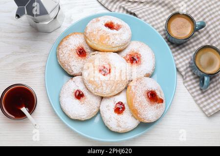Delicious jam donuts served with coffee on white wooden table, flat lay Stock Photo