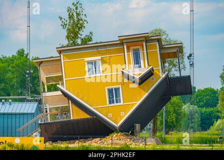 Tagurpidi Maja - a yellow house flipped upside down in Estonain town Tartu. Stock Photo