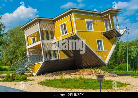 Tagurpidi Maja - a yellow house flipped upside down in Estonain town Tartu. Stock Photo
