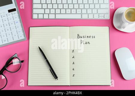 Flat lay composition of notebook with words Business Plan on pink background Stock Photo