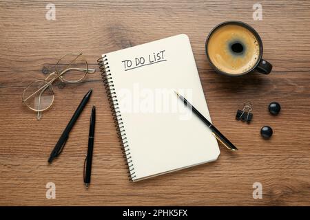 Flat lay composition with unfilled To Do list in notebook and cup of coffee on wooden table Stock Photo