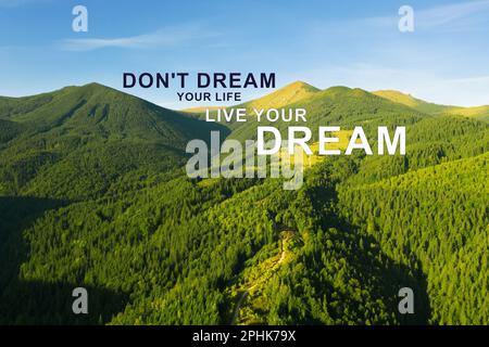 Don't Dream Your Life Live Your Dream. Motivational quote inspiring to make real actions, not only fantasize. Text against beautiful mountain landscap Stock Photo