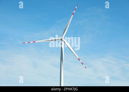 Modern wind turbine against blue sky. Alternative energy source Stock Photo
