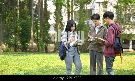 A group of happy young Asian college students are enjoying talking in the campus park together. friendship concept Stock Photo