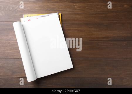 Open magazine with blank page on wooden table, top view. Space for text Stock Photo