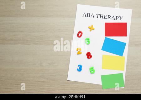 Phrase ABA Therapy and different colors with numbers on white wooden table, top view. Space for text Stock Photo