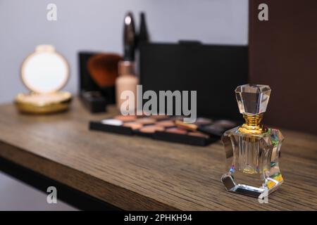 Bottle of perfume and cosmetics on wooden table. Space for text Stock Photo