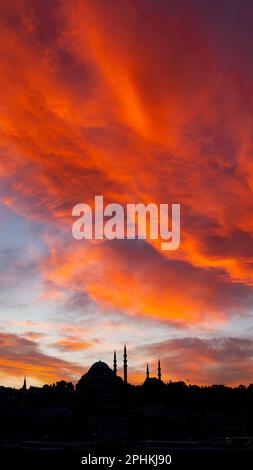 Silhouette of Suleymaniye Mosque and dramatic sky at sunset. Ramadan or islamic or laylat al-qadr or kadir gecesi concept vertical photo. Stock Photo