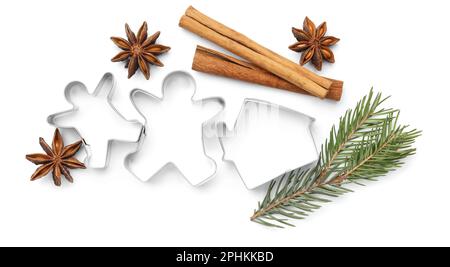 Different cookie cutters, cinnamon sticks, fir branch and anise stars on white background, top view Stock Photo