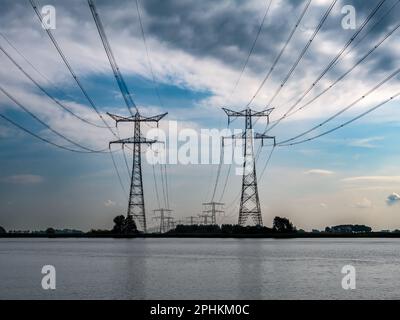 Pylons and high tension power lines over Ramsdiep canal of Zwarte Meer lake, Netherlands Stock Photo