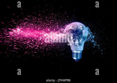 blue and red electric bulb shattering on black background Stock Photo