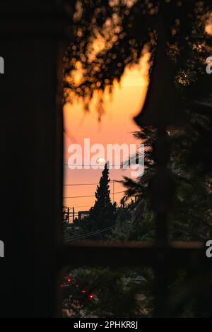 A ccenic view of a residential home's window during sunset Stock Photo