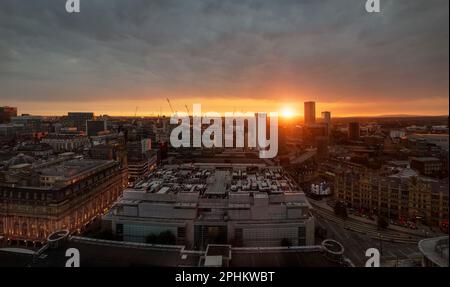 Sunset from central Manchester, a cityscape with the towers and skyscrapers of the city, the shops of the Corn Exchange and the Royal Exchange Theatre Stock Photo