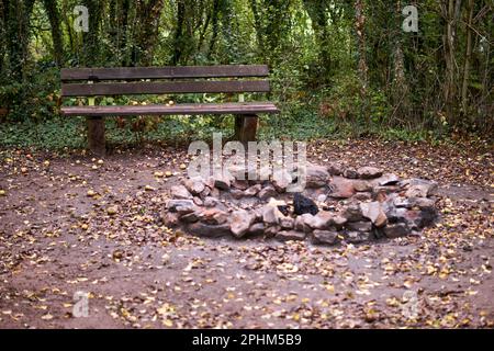 Stone fireplace photographed with a wooden bench in nature. Stock Photo