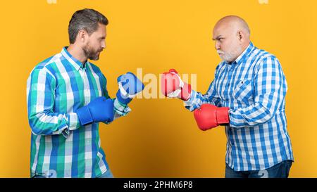 two generation men fighting isolated on yellow. generation men fighting in studio Stock Photo
