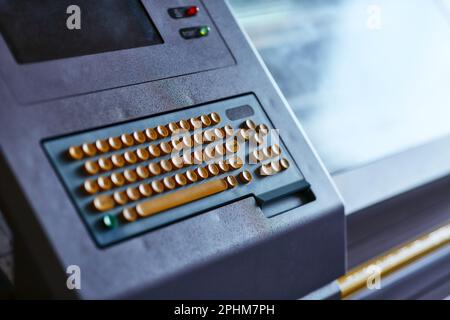 Built-in color keyboard with yellow mechanical buttons for the computer of a large industrial knitting machine with a built-in monitor next to it Stock Photo