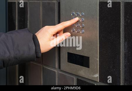 Secure Home System, Hand Pressing on Intercom Keypad, Using Door Phone, Doorphone, Entryphone, Videophone Call, Digital Electronic Doorbell Stock Photo