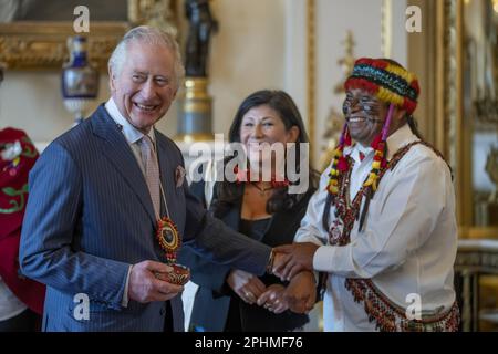 File photo dated 17/02/23 of Amazon Indigenous leader Domingo Peas (right), presents a gift to King Charles III during a reception to discuss the practical delivery of the global biodiversity framework at Buckingham Palace, London. A new portrait of the King by artist Alastair Barford, which was commissioned by the Illustrated London News for the front cover of its special Coronation Editions, depicts the King wearing a bracelet given to him by Domingo Peas. Issue date: Wednesday March 29, 2023. Stock Photo
