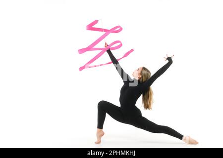 Girl gymnast in a black tight-fitting jumpsuit with a pink ribbon on a white background Stock Photo