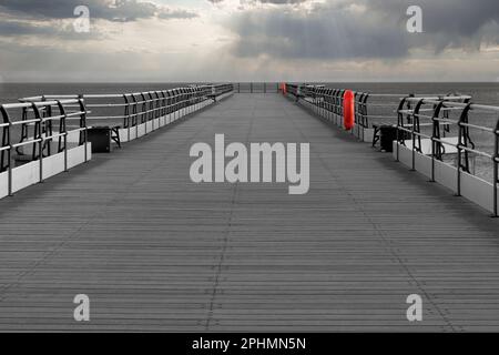 Saltburn pier with its wooden board flooring stretching into the horizon.   The last pier in Yorkshire. Stock Photo