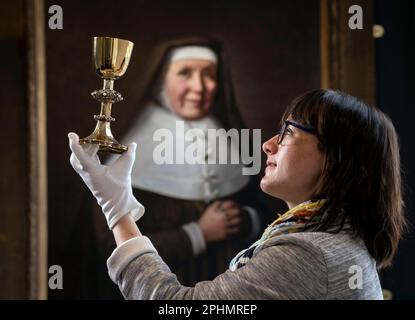 Special collections manager Dr Hannah Thomas holds the 1630s recusant chalice with depictions of the Stations of the Cross on display at the Bar Convent in York, the oldest living convent in the UK, as part of an exhibition for Easter. Picture date: Wednesday March 29, 2023. Stock Photo